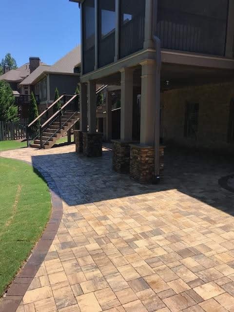 Paver Patio Extending Beyond an Enclosed Deck by Sugar Hill Outdoors